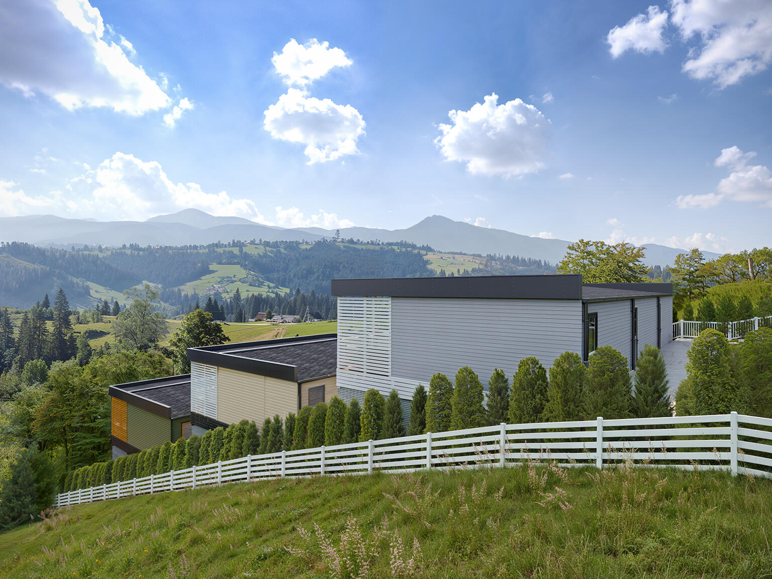 High quality 3D render of a modern house nestled in a mountain landscape, highlighting the scenic views and green surroundings
