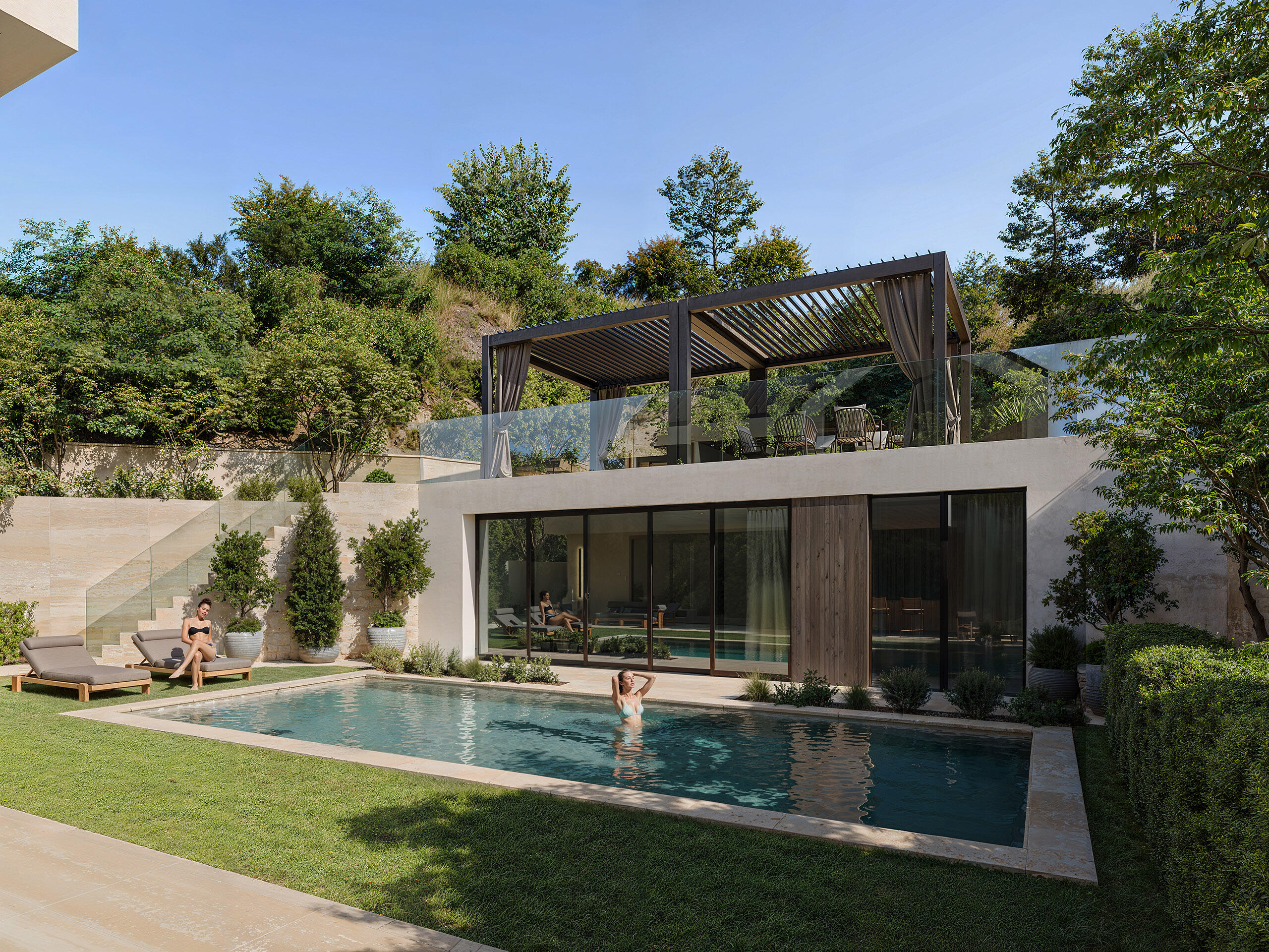 Luxury villa with swimming pool and wooden pergola in landscaped garden